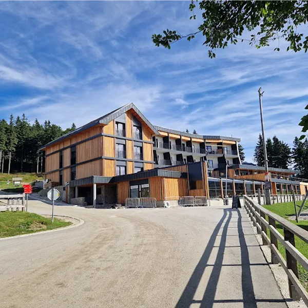 Pogled na festivalsko prizorišče na Kopah, obdano z gozdovi in gorsko naravo.